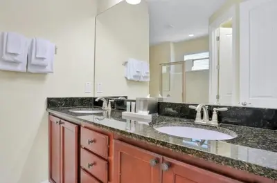 a bathroom with two sinks and a large mirror at 351-AFV · 351 hiden retreat 6bepoolgameroom in Orlando