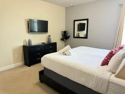 a bedroom with a bed and a tv on the wall at 351-AFV · 351 hiden retreat 6bepoolgameroom in Orlando