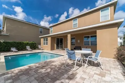 a patio with a table and chairs next to a pool at 351-AFV · 351 hiden retreat 6bepoolgameroom in Orlando