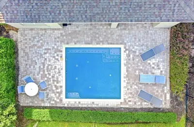 an overhead view of a swimming pool on a brick building at 351-AFV · 351 hiden retreat 6bepoolgameroom in Orlando