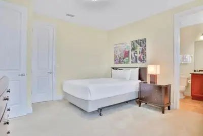 a white bedroom with a large bed and a table at 351-AFV · 351 hiden retreat 6bepoolgameroom in Orlando