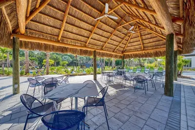 a patio with tables and chairs under a wooden roof at Vacation Bliss-Prime Resort Unbeatable Location in Kissimmee