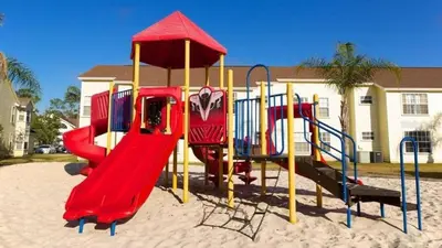 a playground in the sand in front of a house at Gorgeous Place Minutes Away from Attractions in Kissimmee