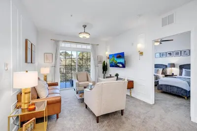 a living room with a couch and a bed at The Secret Rose Apartment - Modern & Stylish - 8 Mins from Disney in Kissimmee