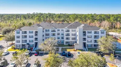an aerial view of a building with a parking lot at The Secret Rose Apartment - Modern & Stylish - 8 Mins from Disney in Kissimmee