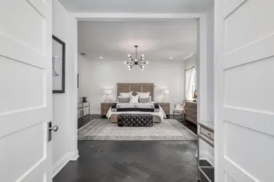 a white bedroom with a bed and a chandelier at Celebration FL 34747 in Orlando