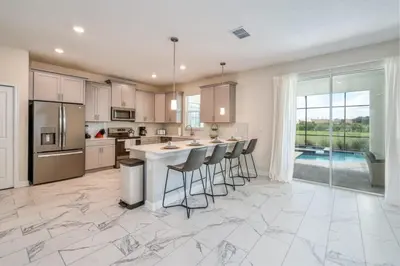 a kitchen with a island with bar stools at Chic Luxury Decor Prime Location Game Room Bliss in Kissimmee