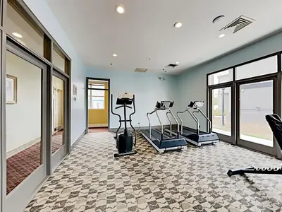 a gym with treadmills and elliptical machines at DisneyResortVillas by AmericanVacationLiving 1 BR in Orlando
