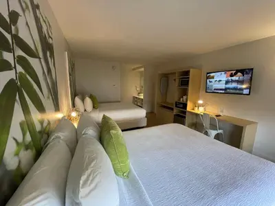 a bedroom with a bed and a tv on the wall at Newly renovated room in cozy hotel near Disney 2 in Kissimmee