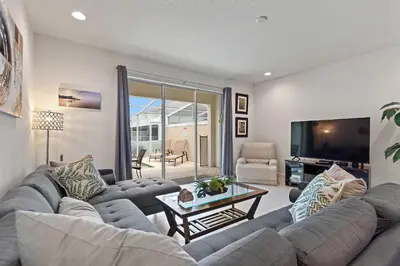 a living room with a large couch and a tv at Priceless Peace at Serenity by Shine Villas, 081 townhouse in Orlando