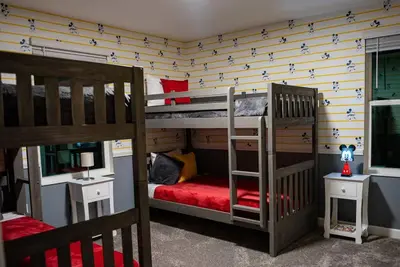 a bedroom with two bunk beds and a tv at Luxury and Fun near DISNEY PARKS 9BR in Kissimmee
