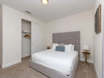 a bedroom with a large white bed with a silver headboard at Gorgeous Remo 8 BR at Encore Resort next to Disney in Orlando