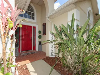 a red door on a house with plants at No place like home in Oviedo