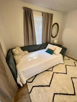 a bed sitting in a room with a window at Beautiful Bungalow in Orlando