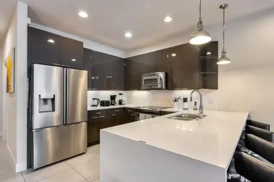 a kitchen with a stainless steel refrigerator and white counter top at Distinctive Home Private Pool in Orlando