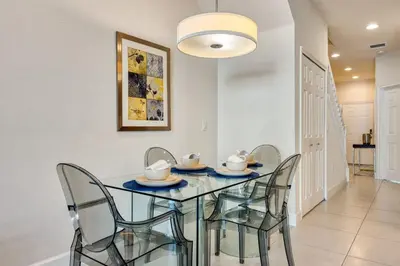 a dining room with a glass table and chairs at Distinctive Home Private Pool in Orlando