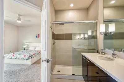 a bathroom with a shower and a sink and a bed at Distinctive Home Private Pool in Orlando