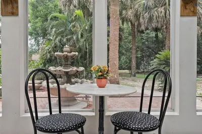 a table and two chairs with a fountain in a yard at 4,800 sf Estate Pool Lake Weddings and Events in Orlando