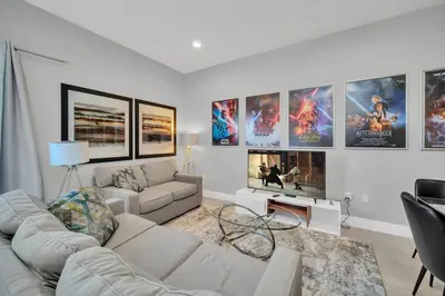 a living room with a lot of movie posters on the wall at NEW awesome dream house, 5 Min to Disney in Orlando