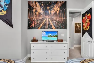 a bedroom with a white dresser with a television on it at NEW awesome dream house, 5 Min to Disney in Orlando