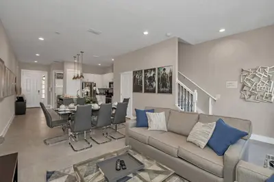 a living room with a couch and a dining room at New Awesome decorated dreamhouse in Orlando