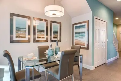 a dining room with a glass table and chairs at Super cozy home with private pool in Orlando