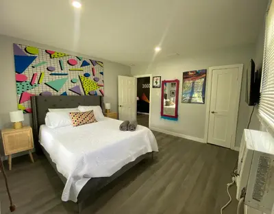 a bedroom with a bed with a painting on the wall at Totally 80s! in Sanford