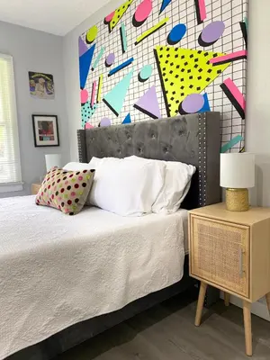 a bedroom with a bed and a colorful wall at Totally 80s! in Sanford