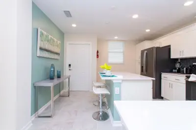 a kitchen with a white counter and a refrigerator at Poolside Paradise at Storey Lake: 2-Bedroom in Kissimmee