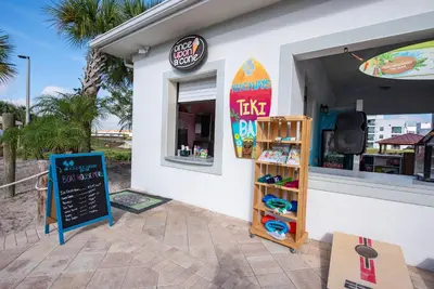 a surf shop with a surfboard on the side of it at Poolside Paradise at Storey Lake: 2-Bedroom in Kissimmee