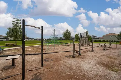 an empty park with a playground with swings at Poolside Paradise at Storey Lake: 2-Bedroom in Kissimmee