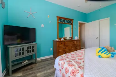 a bedroom with blue walls and a tv and a bed at Mickey's Whimsical Wonderland in Kissimmee
