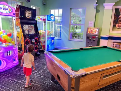 a young child standing in front of a pool table at Windsor Palms, next to clubhouse in Kissimmee