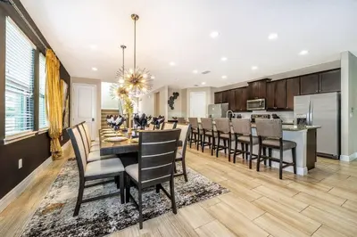 a dining room and kitchen with a table and chairs at EPIC 10min Disney Fun Villa, Mini Golf, Arcade, Theater in Orlando