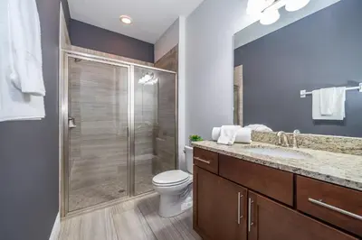 a bathroom with a shower and a toilet and a sink at EPIC Disney 10Min Retreat, 8BR Resort Villa and Arcade in Orlando