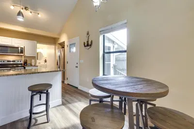a kitchen with a wooden table and two stools at St Cloud Vacation Rental - Walk to Lakefront Park! in Saint Cloud