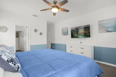 a bedroom with a blue bed and a ceiling fan at Super Deal - Brand New Themed 9BR Home near Disney in Kissimmee
