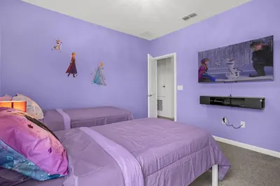 a purple bedroom with two beds with purple walls at Super Deal - Brand New Themed 9BR Home near Disney in Kissimmee
