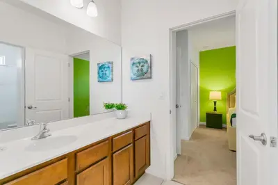 a bathroom with a sink and a mirror at Modern 6BR Home - Pool Games BBQ - Near Disney in Kissimmee