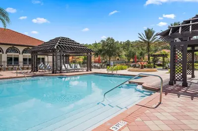 a large swimming pool with a gazebo at Modern 6BR Home - Pool Games BBQ - Near Disney in Kissimmee