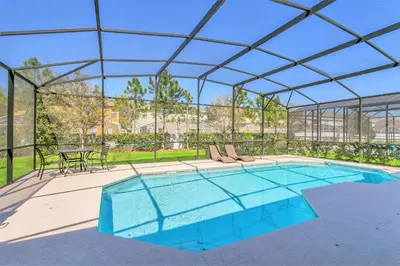a swimming pool with a clear roof with a pool at Modern 6BR Home - Pool Games BBQ - Near Disney in Kissimmee