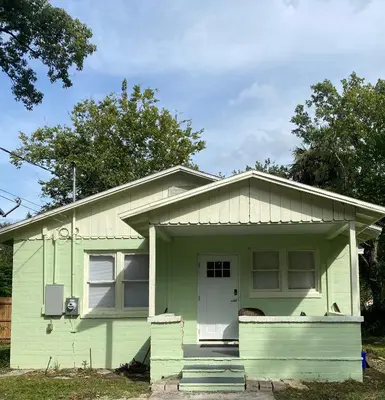 a green house with a white door at The Oasis in Sanford