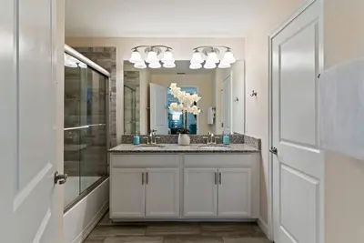 a bathroom with a sink and a mirror at Family Fun with Mickey and Frozen at Storey Lake in Kissimmee