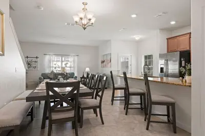 a kitchen and dining room with a table and chairs at Storey Lake Townhome fun for families at Remy's Retreat in Kissimmee