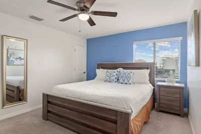 a bedroom with a bed and a ceiling fan at Storey Lake Townhome fun for families at Remy's Retreat in Kissimmee