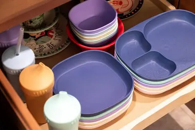 a pile of plates and bowls on a shelf at Storey Lake Townhome fun for families at Remy's Retreat in Kissimmee
