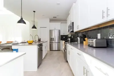 a kitchen with white cabinets and stainless steel appliances at Super Luxury Modern Home, Prime Location in Kissimmee