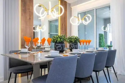 a dining room with a long table and blue chairs at WonderFul 4Bd w Pool Close to Disney at StoreyLake 2669 in Kissimmee