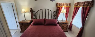 a bedroom with a large red bed with two windows at Emerald Island Diamond on the Island in Kissimmee