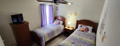 a bedroom with two twin beds and a television at Emerald Island Diamond on the Island in Kissimmee